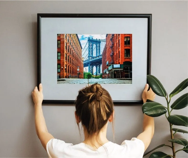 A framed print being hung on a wall