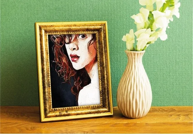 A gold framed portrait behind glass